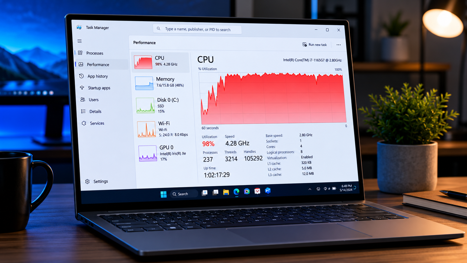 Laptop with Task Manager showing high CPU usage at 98 percent