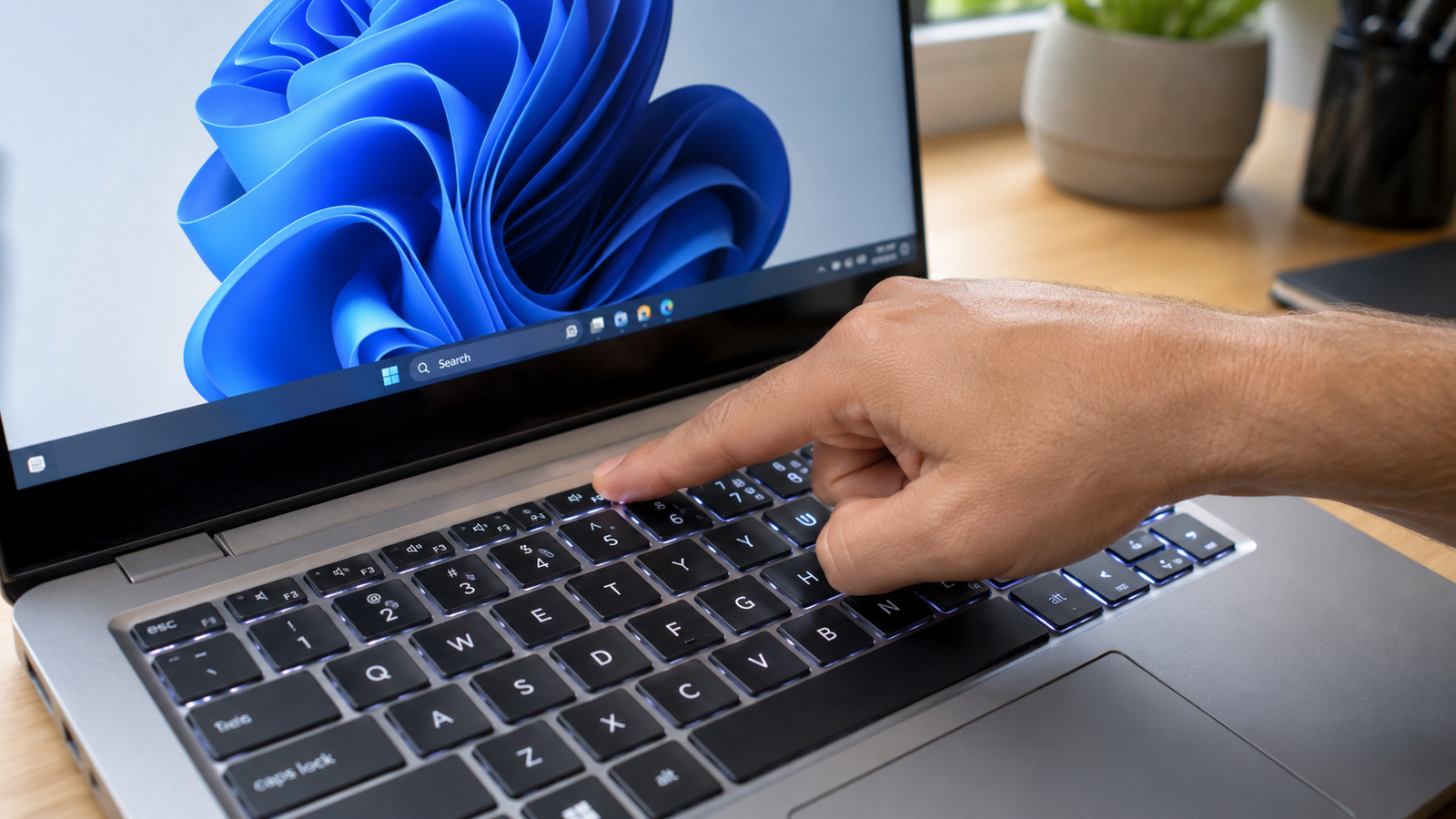Technician pressing a function key on a laptop keyboard to troubleshoot a not working issue